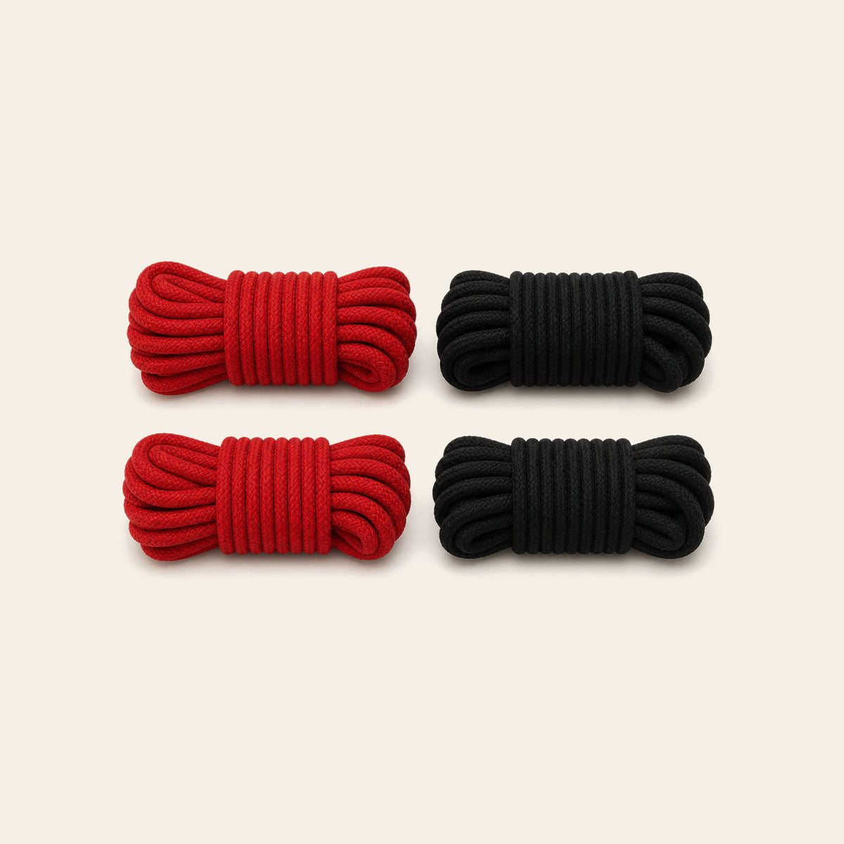 Four coiled soft cotton bondage ropes in red and black on a soft beige background — Femme Bliss SilkBind