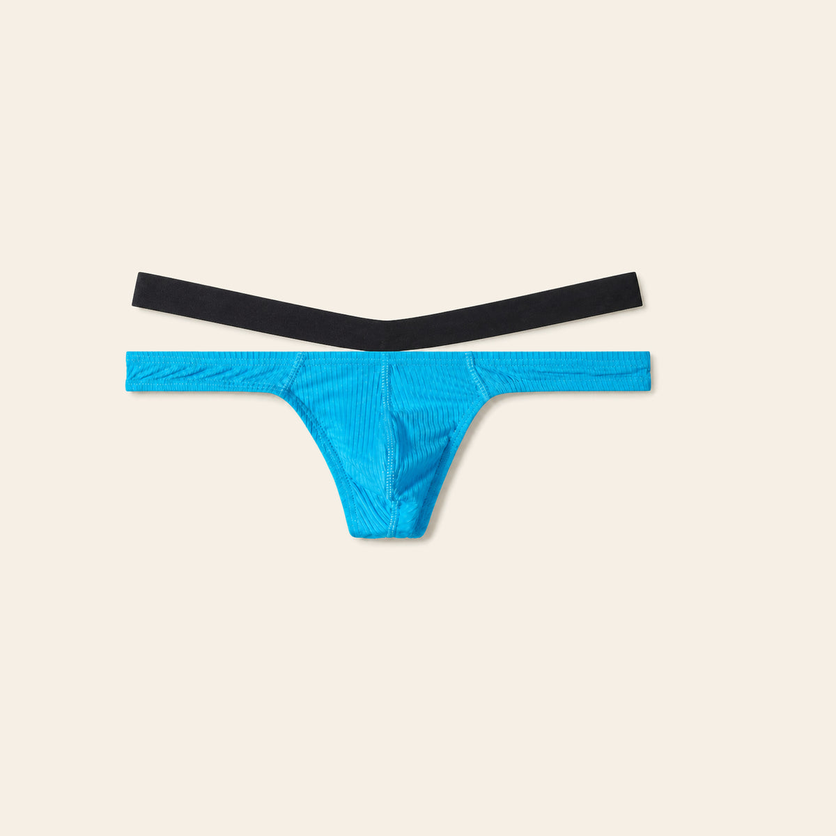 Men's low-rise thong in blue with a contoured pouch and slim waistband, on a soft beige background