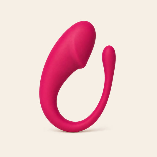Deep pink silicone panty vibrator with a flexible arm on a soft beige background — Femme Bliss Nova
