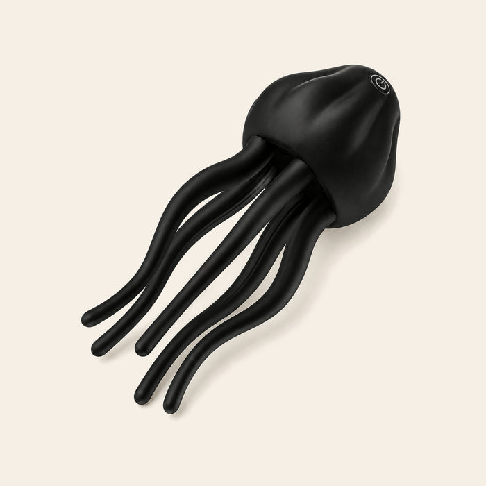 Black silicone stroker with a domed body and soft tentacle-style arms on a soft beige background — Femme Bliss TentacleTouch