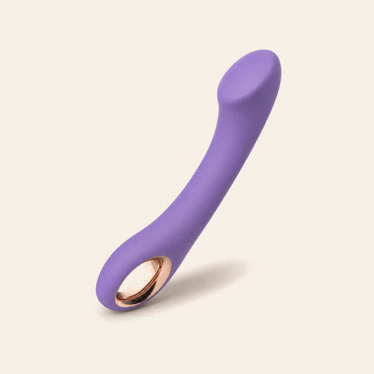 Curved G-spot vibrator in light purple with a rose-gold base ring, on a soft beige background — Femme Bliss Velvet Pulse