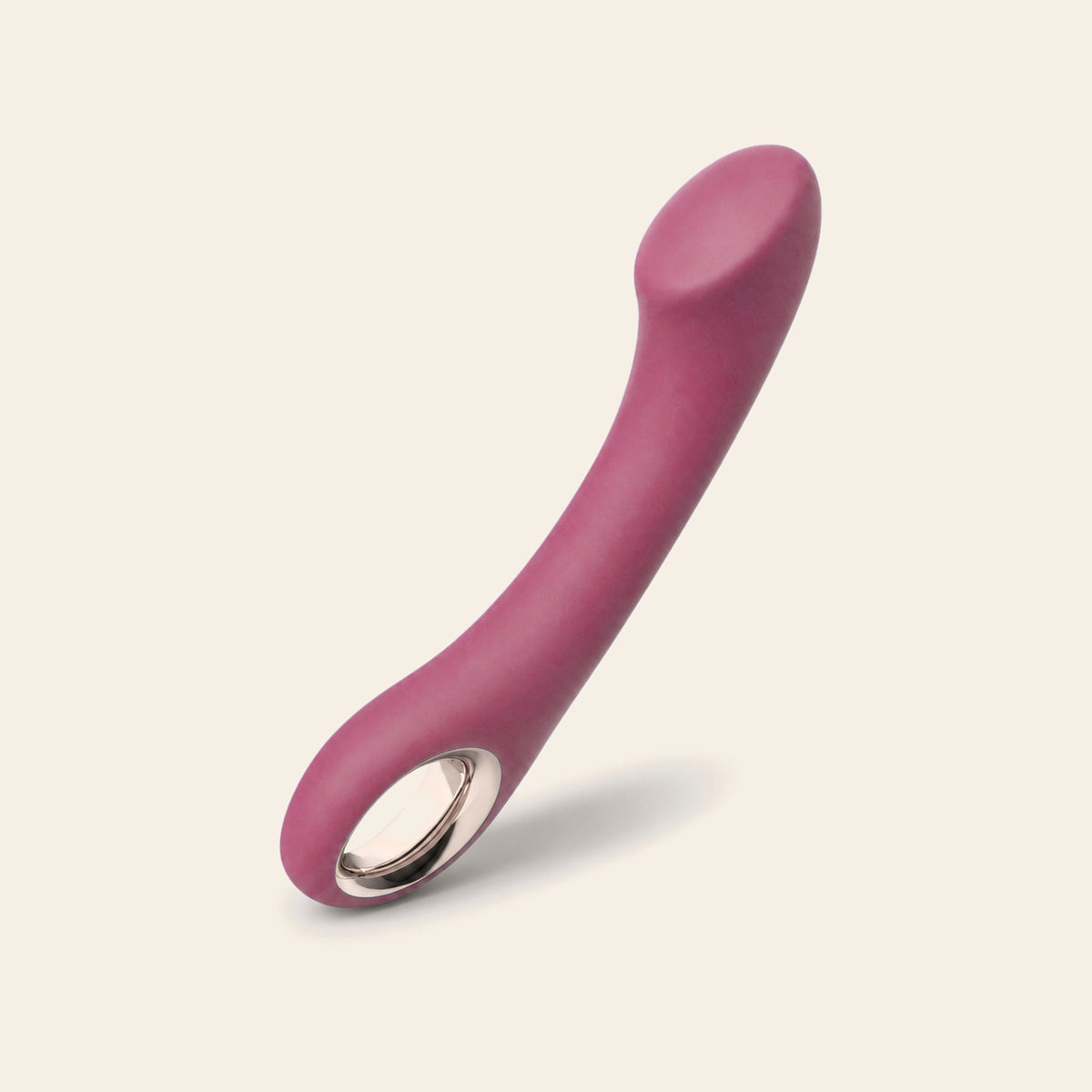 Curved G-spot vibrator in rose red with a rose-gold base ring, on a soft beige background — Femme Bliss Velvet Pulse