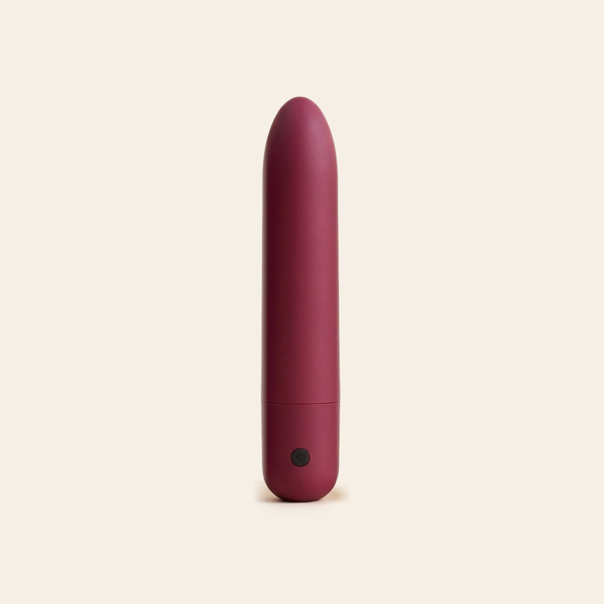 Matte rose red bullet vibrator with a single button at the base, on a soft beige background — Femme Bliss Bliss Bullet