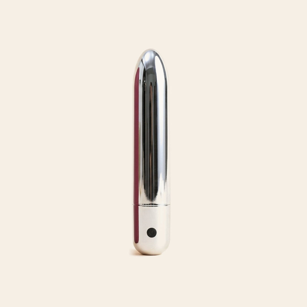 Polished silver bullet vibrator with a single button at the base, on a soft beige background — Femme Bliss Bliss Bullet