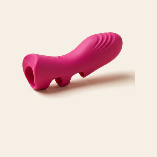 Magenta silicone finger vibrator with ridged tip and finger loop on a soft beige background — Femme Bliss BlissIgnite Touch