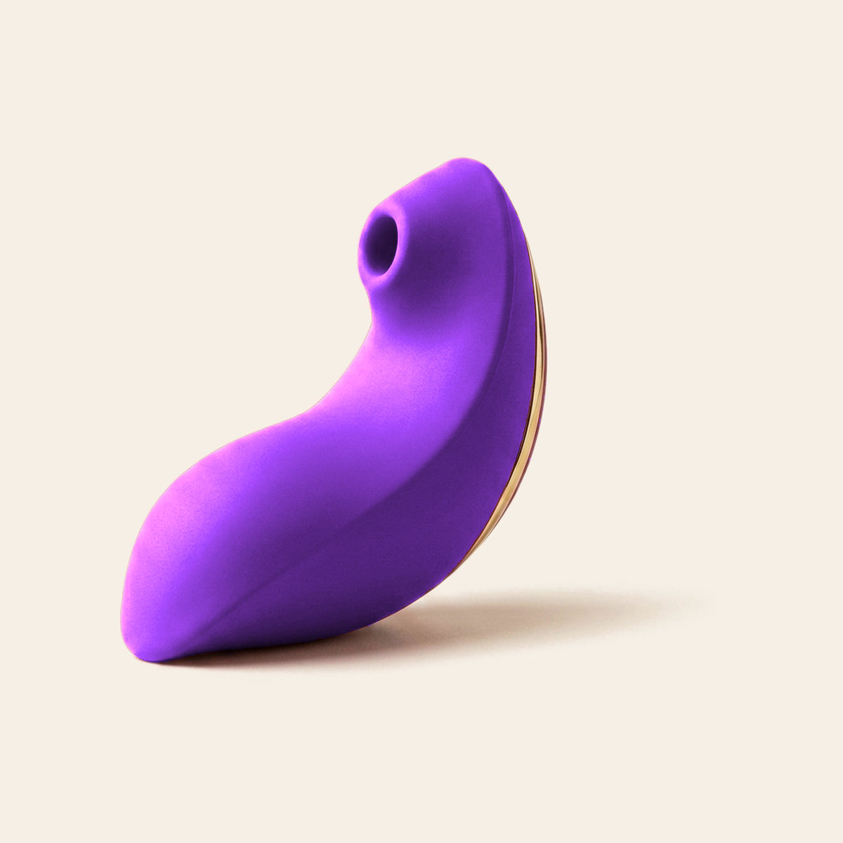 Purple wearable suction vibrator with gold trim on a soft beige background — Femme Bliss BlissWave