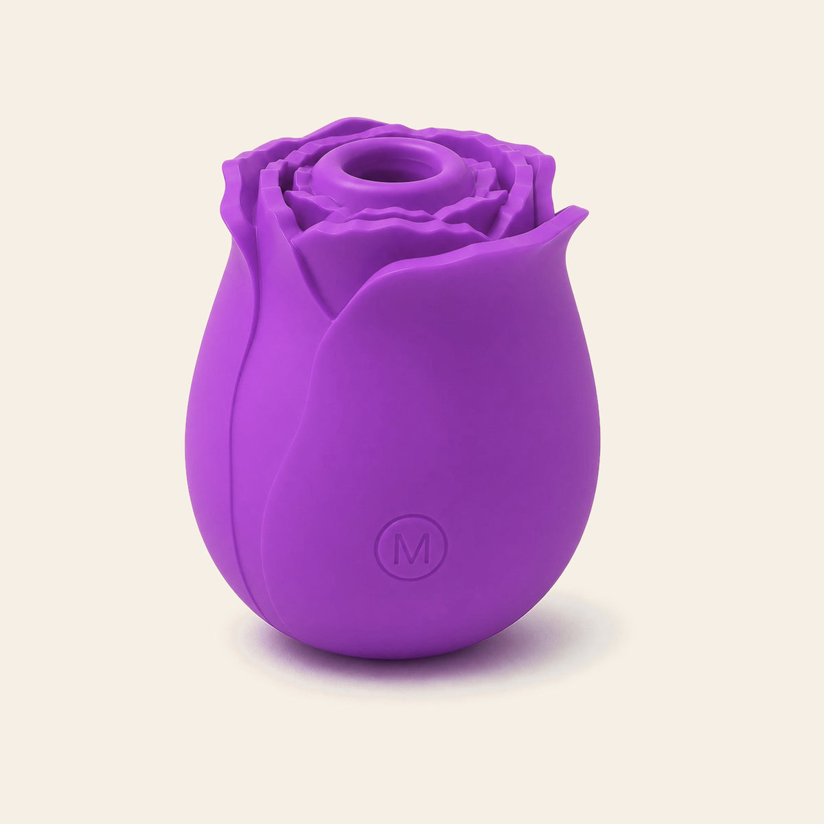 Rose-shaped silicone clitoral suction vibrator in purple on a soft beige background — Femme Bliss BloomPulse Rose