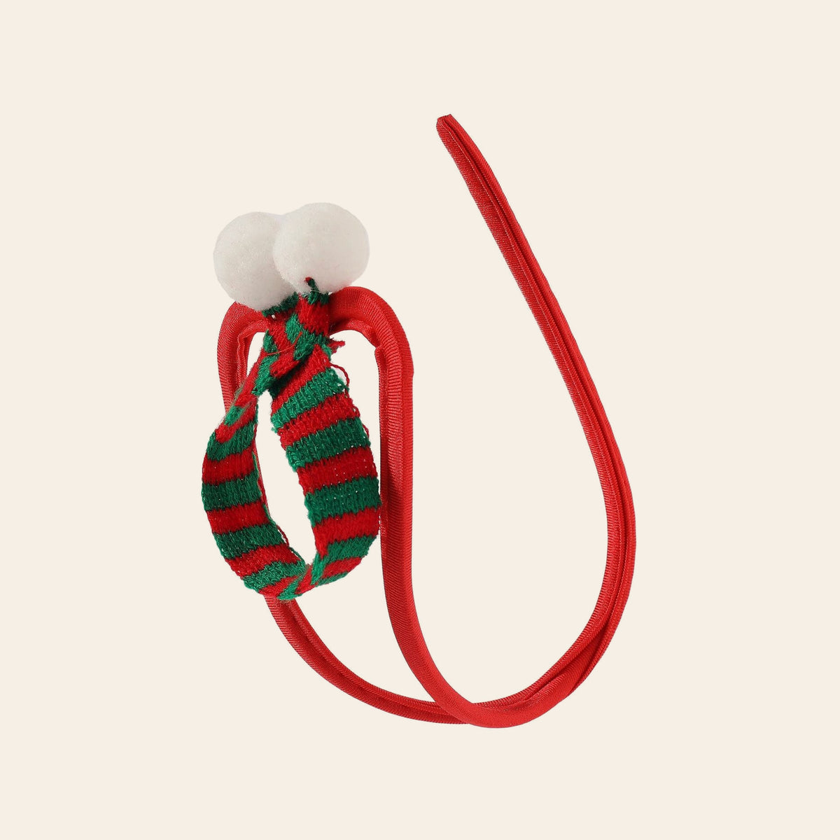 Men's festive C-string with a red cord waistband and a red-and-green striped knitted pouch with white pom-poms, on a soft beige background