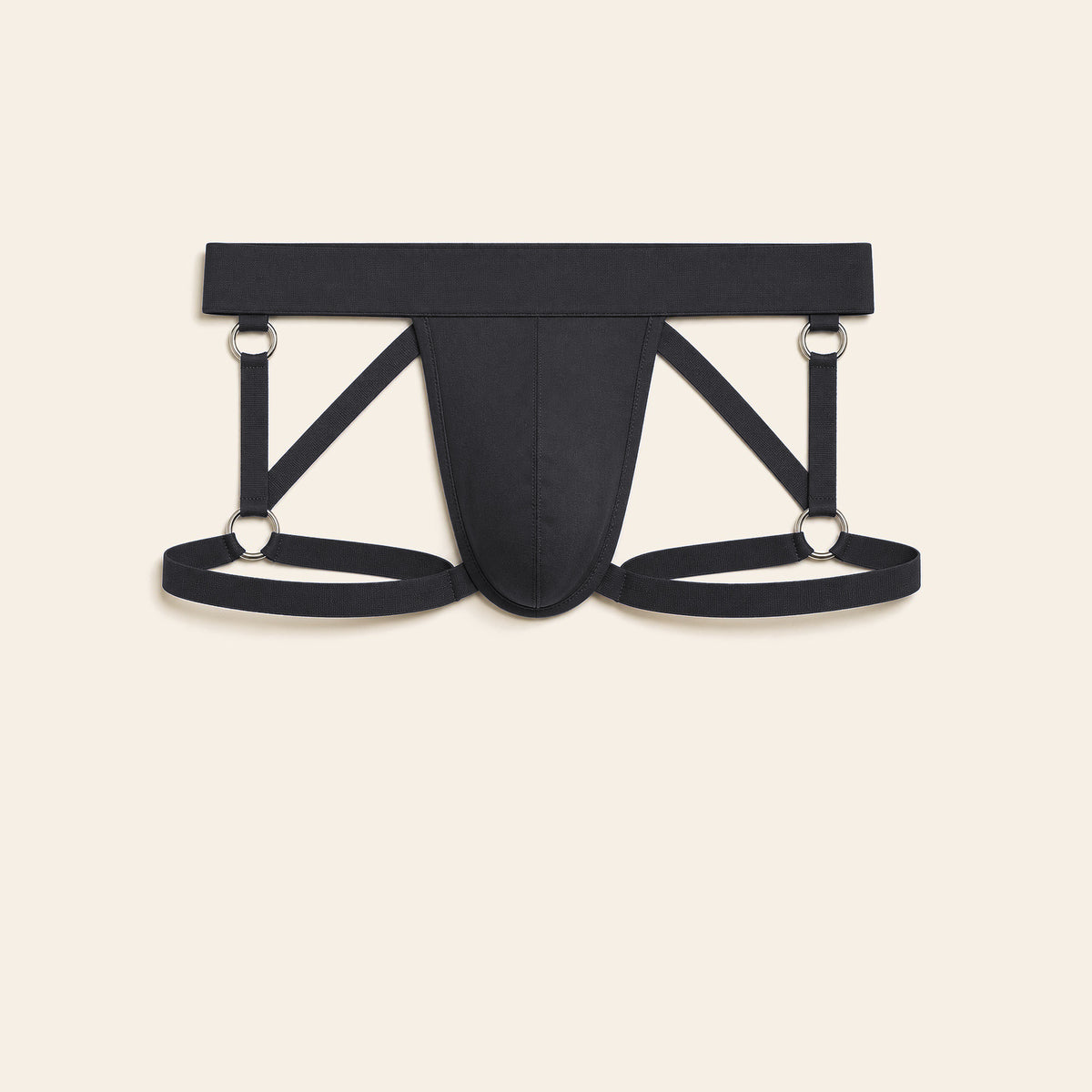 Men's strappy harness brief in black with an open cutout front and elastic thigh straps on a soft beige background — Femme Bliss Strappy Harness