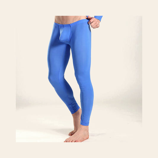 Model wearing men's seamless ice silk leggings in blue with a dual-pouch front, full-length view, on a soft beige background
