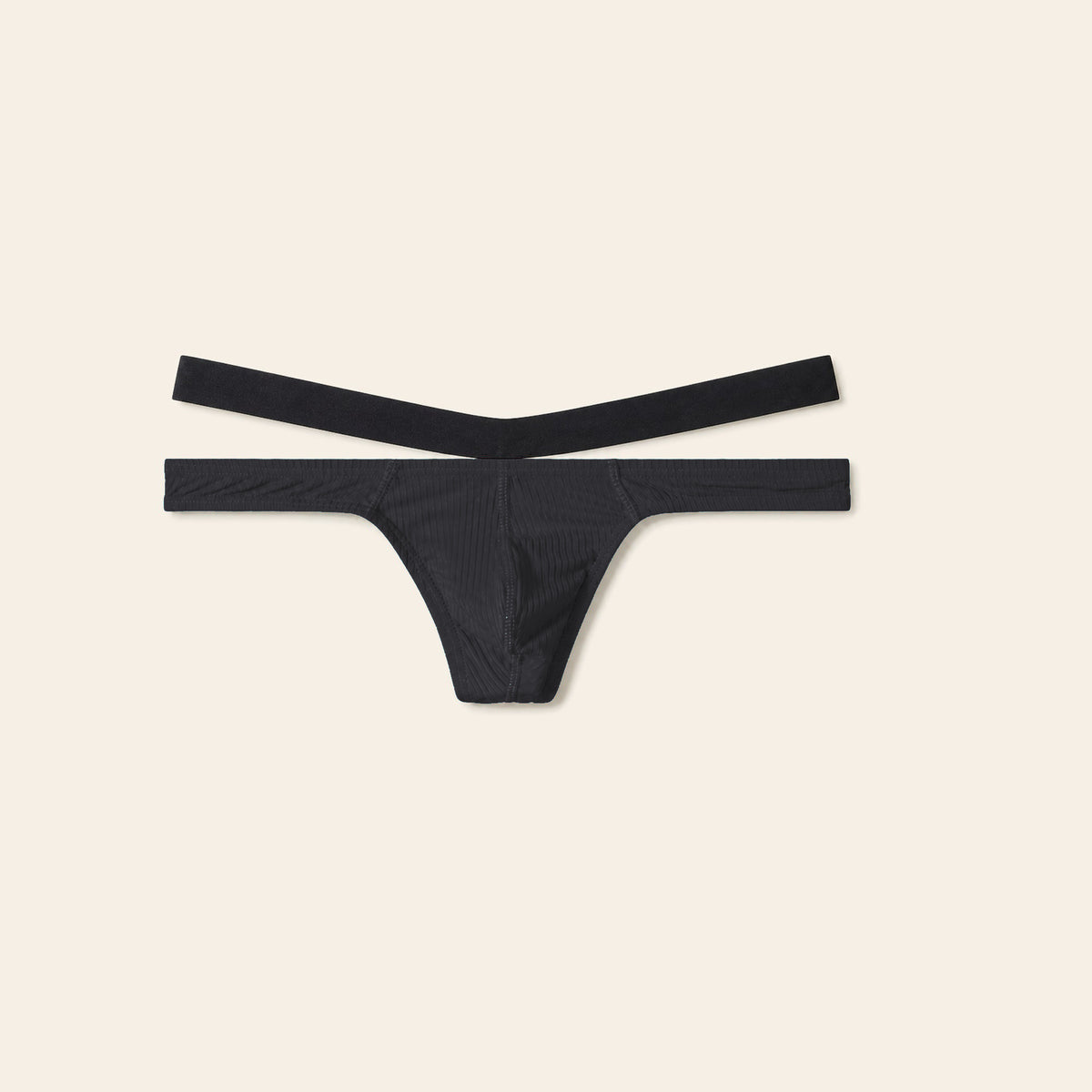 Men's low-rise thong in black with a contoured pouch and slim waistband on a soft beige background — Femme Bliss Low-Rise Thong