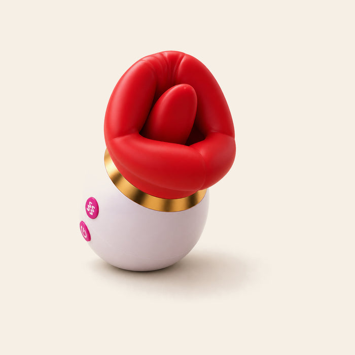 Egg-shaped silicone vibrator with sculpted red lip-and-tongue top and gold accent ring on a soft beige background — Femme Bliss LushKiss