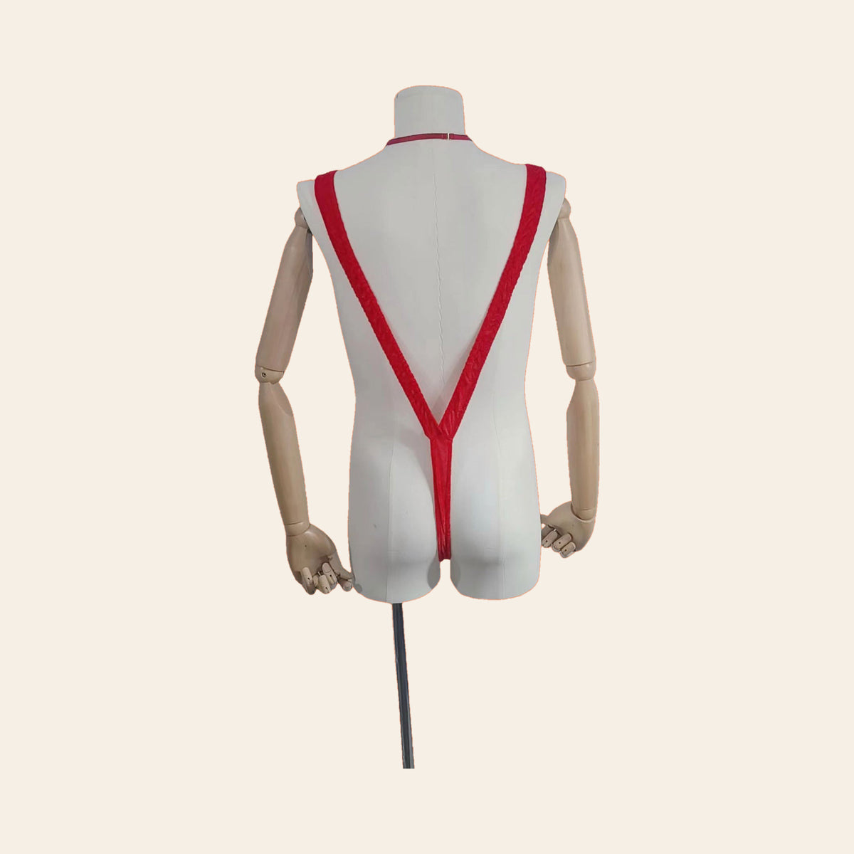 Santa V-string thong on a mannequin, back view: red straps meeting in a thong back, on a soft beige background — Femme Bliss