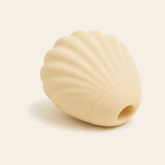Ivory shell-shaped silicone suction vibrator with ridged texture on a soft beige background — Femme Bliss SeaShell Bliss