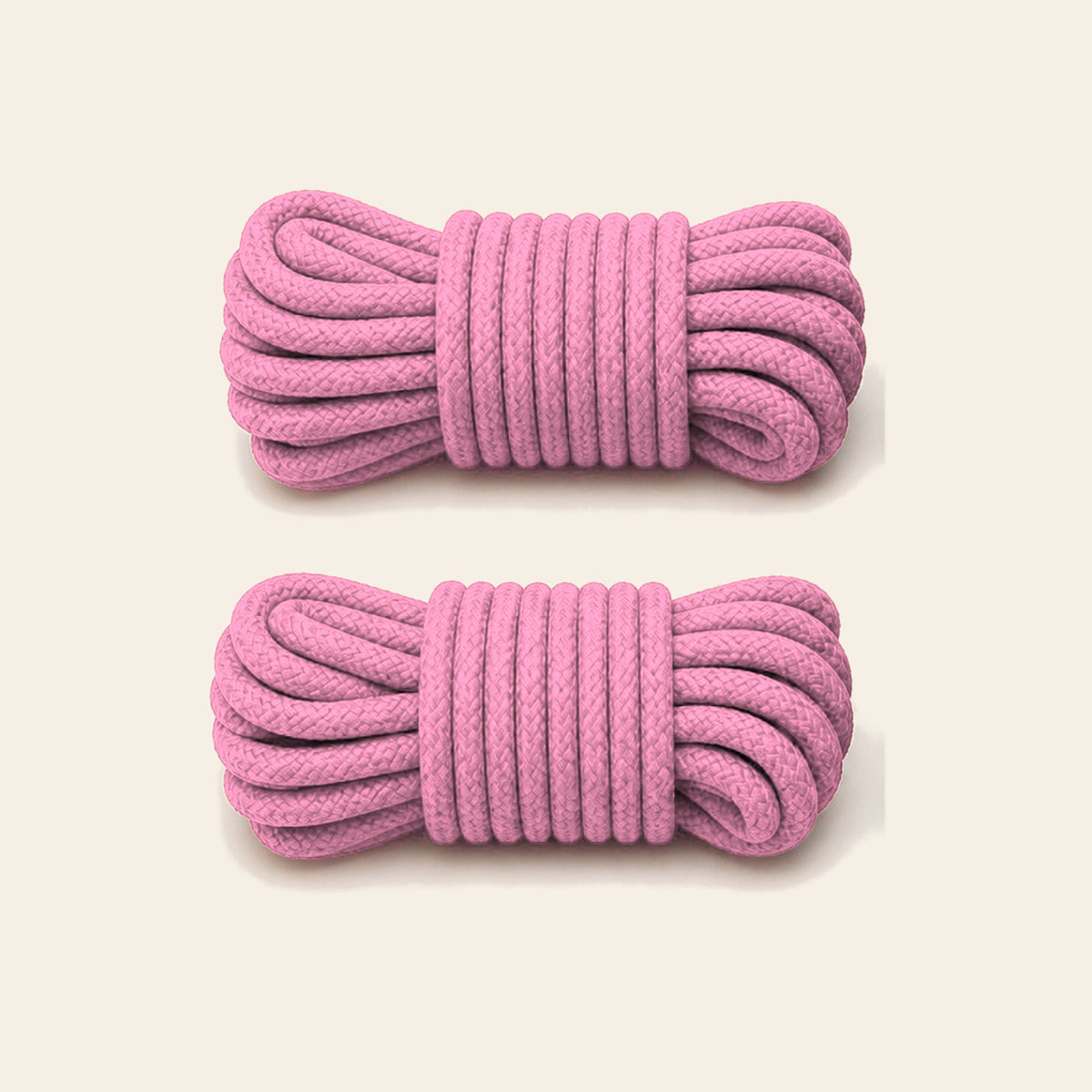 Two coiled pink soft bondage ropes on a soft beige background — Femme Bliss SilkBind