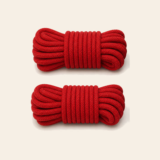Two coiled red soft bondage ropes on a soft beige background — Femme Bliss SilkBind