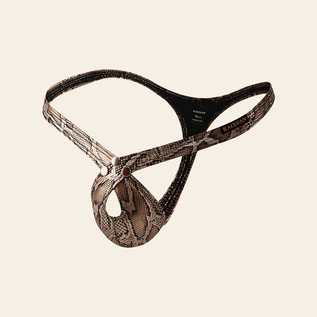 Men's low-rise thong in metallic snakeskin-effect fabric with a contoured pouch, on a soft beige background
