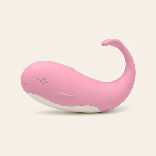 Pale pink whale-shaped silicone wearable vibrating egg on a soft beige background — Femme Bliss TidalBliss