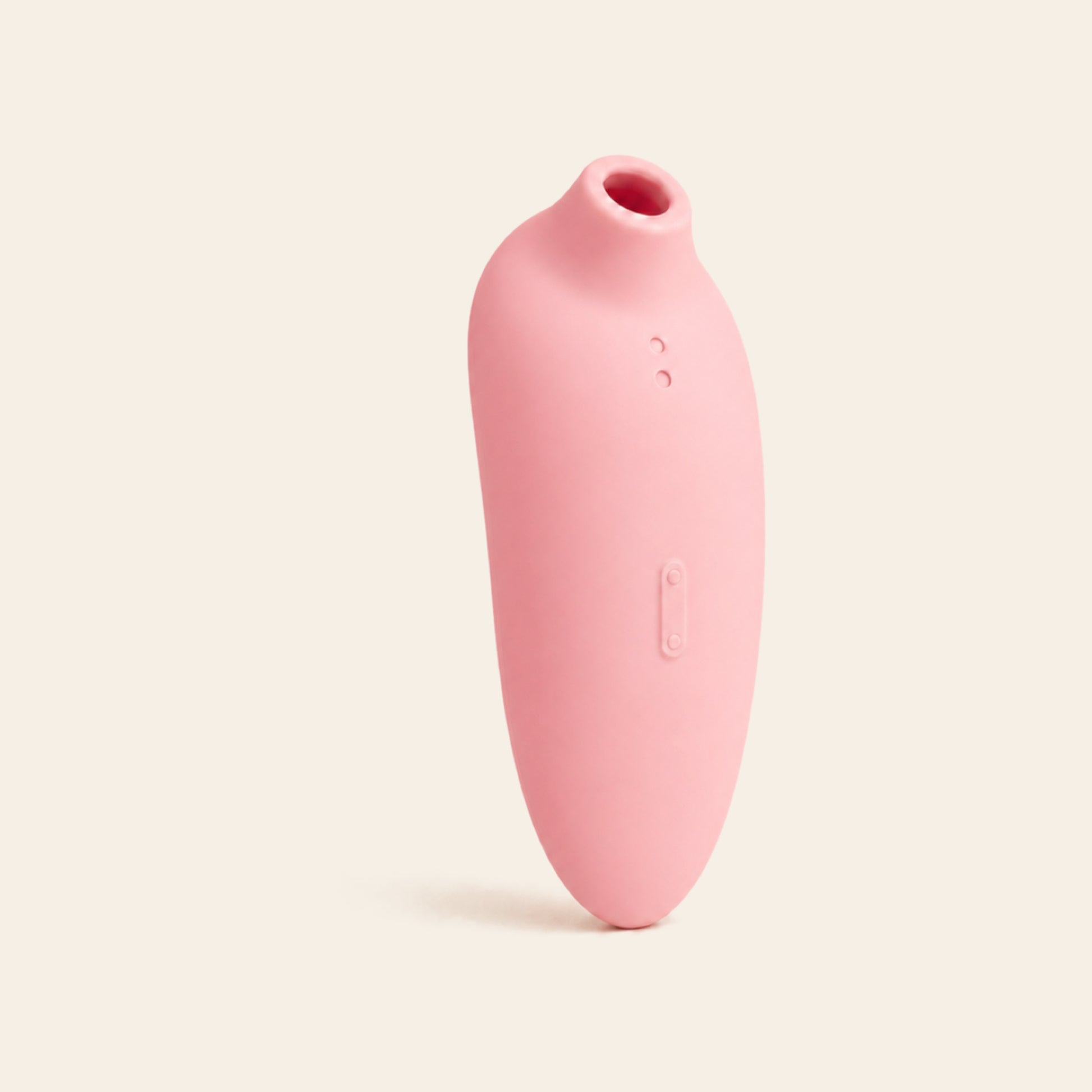 Blush pink suction vibrator with rose-gold lower body on a soft beige background — Femme Bliss VelvetArc