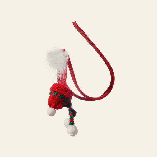 Men's novelty Christmas C-string with a red cord waistband and a knitted Santa hat pouch with white pom-poms, on a soft beige background